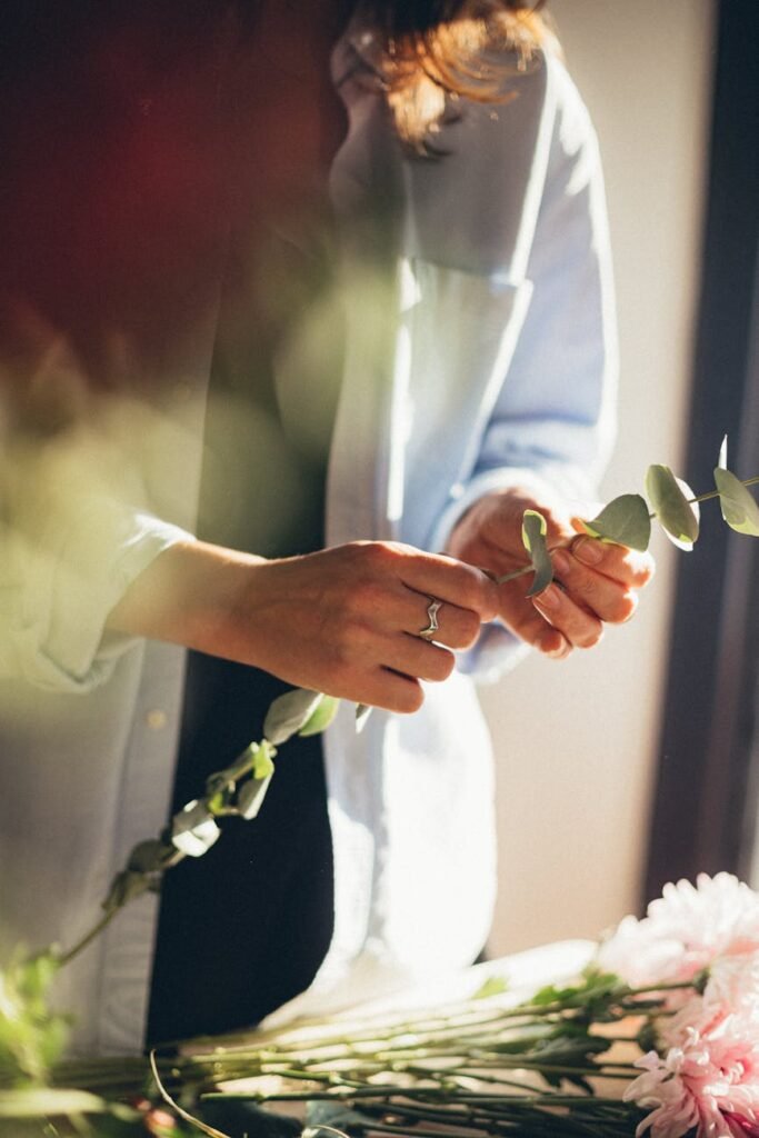 woman in white dress shirt arranging flowers